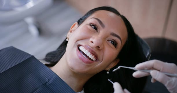 Patient smiling after a dental check-up at the Biolume studio