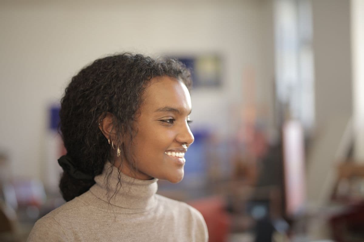 Smiling woman in soft natural light, for a guide to dark gums treatment and laser gum bleaching in Vashi