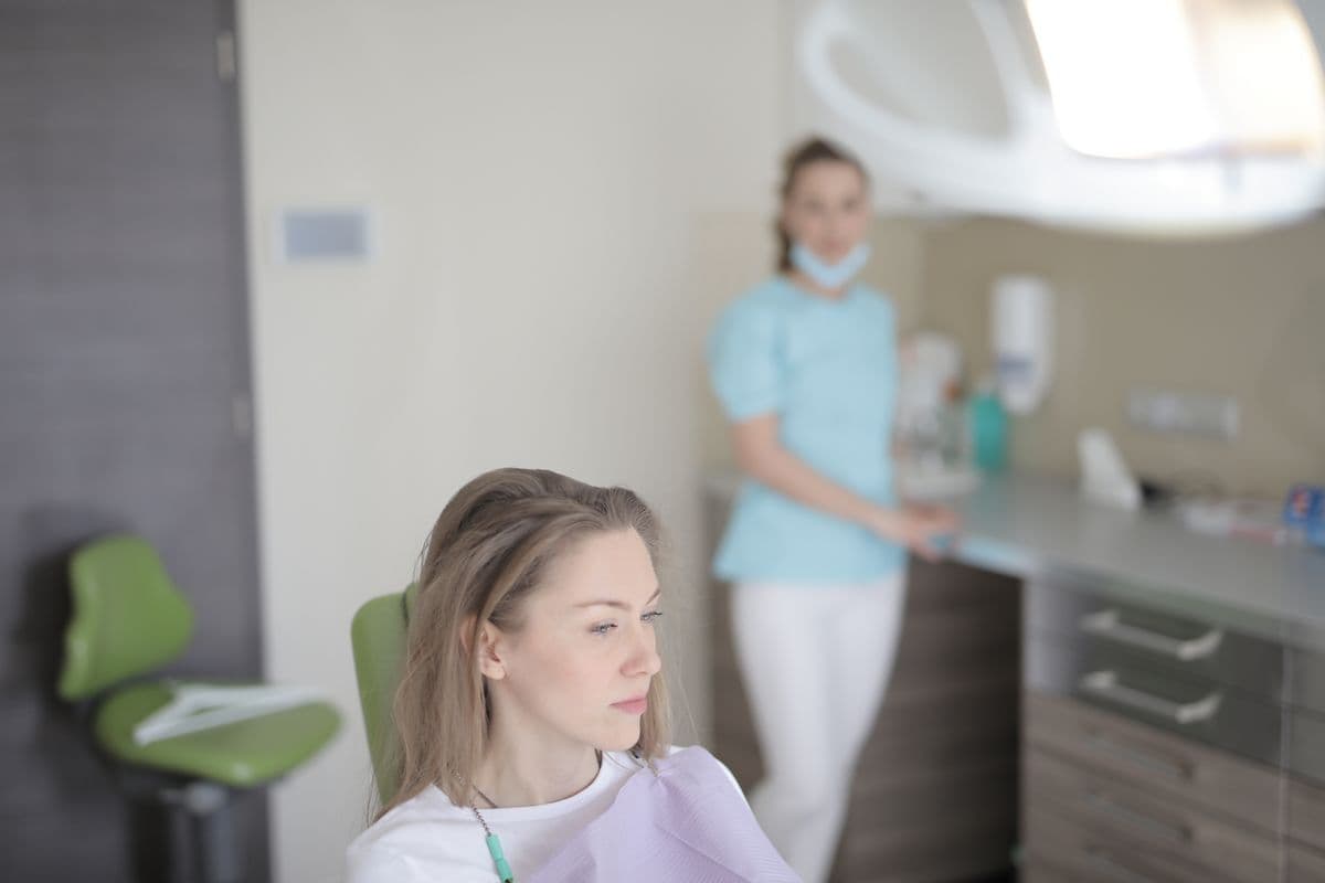 Thoughtful patient waiting in a dental chair, for a guide to dental anxiety and gentle dentists in Vashi
